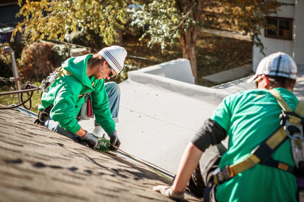 Solar panel installation crew members on roof of house - Kempthorne Roofing & Construction